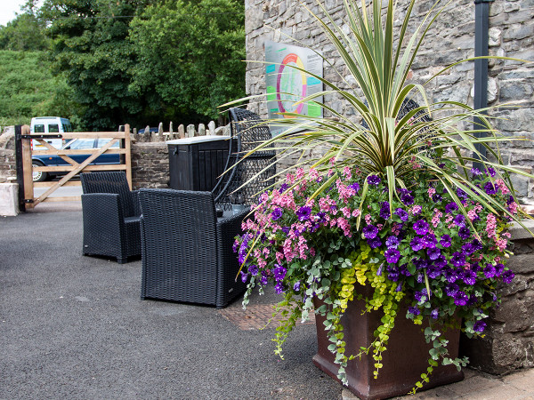 Sgwd Gwladys Coffee House, Bar & Lodge with pots and seating for their customers to enjoy.